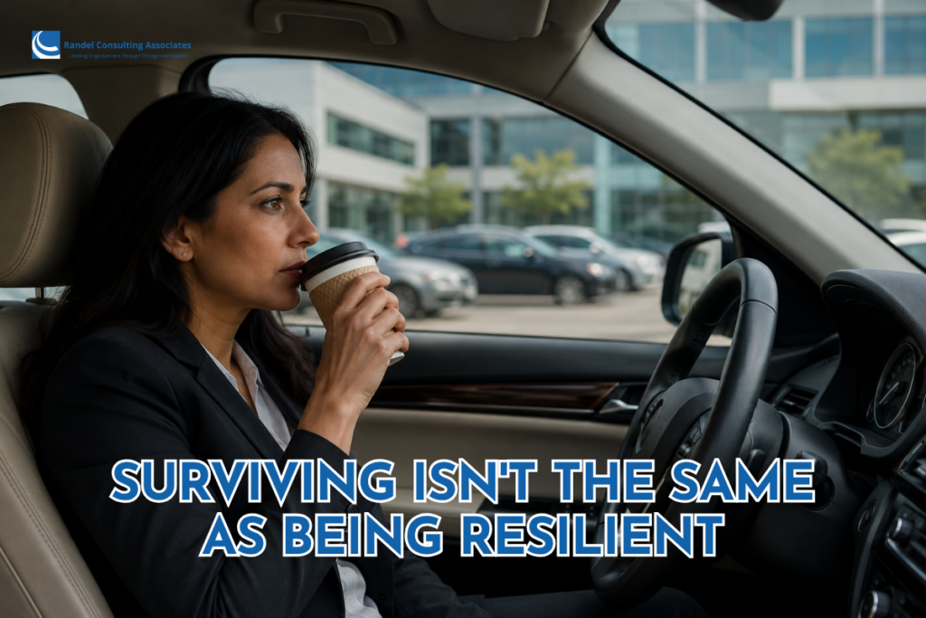Professional woman sitting behind the steering wheel of her car in an office parking lot, thoughtfully sipping coffee from a disposable cup before heading into work.